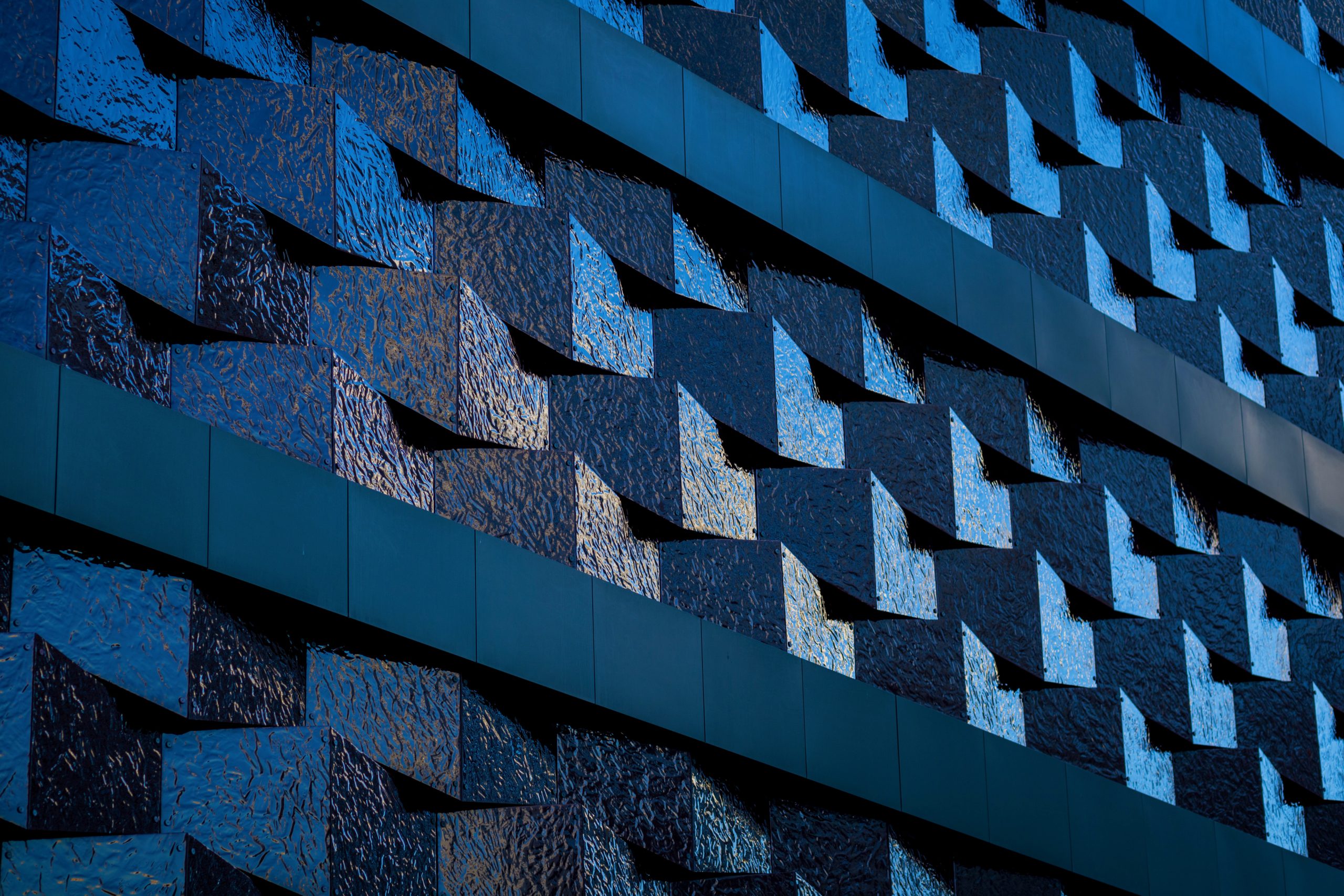 Abstract geometric building facade with repeating blue textured panels