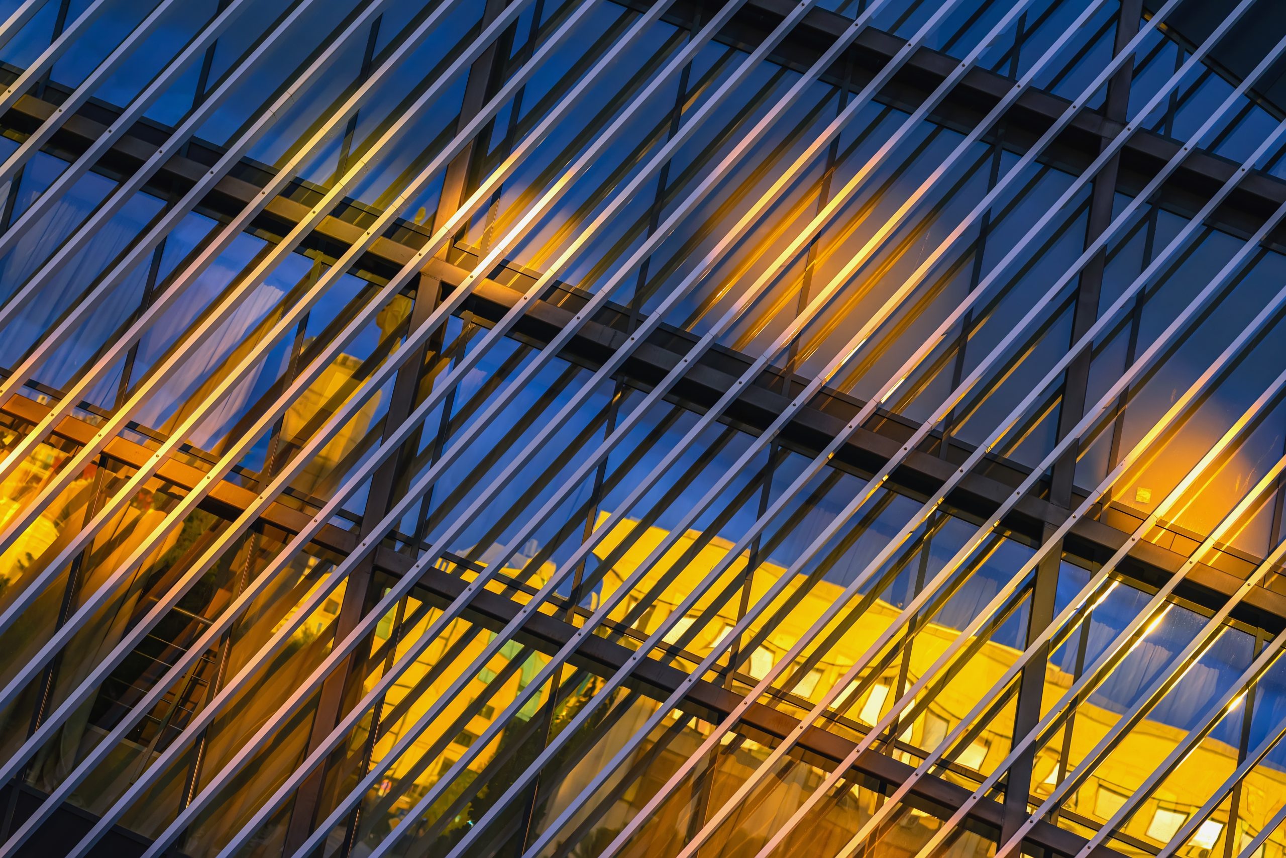 Abstract close-up of a modern glass building with yellow and blue reflections