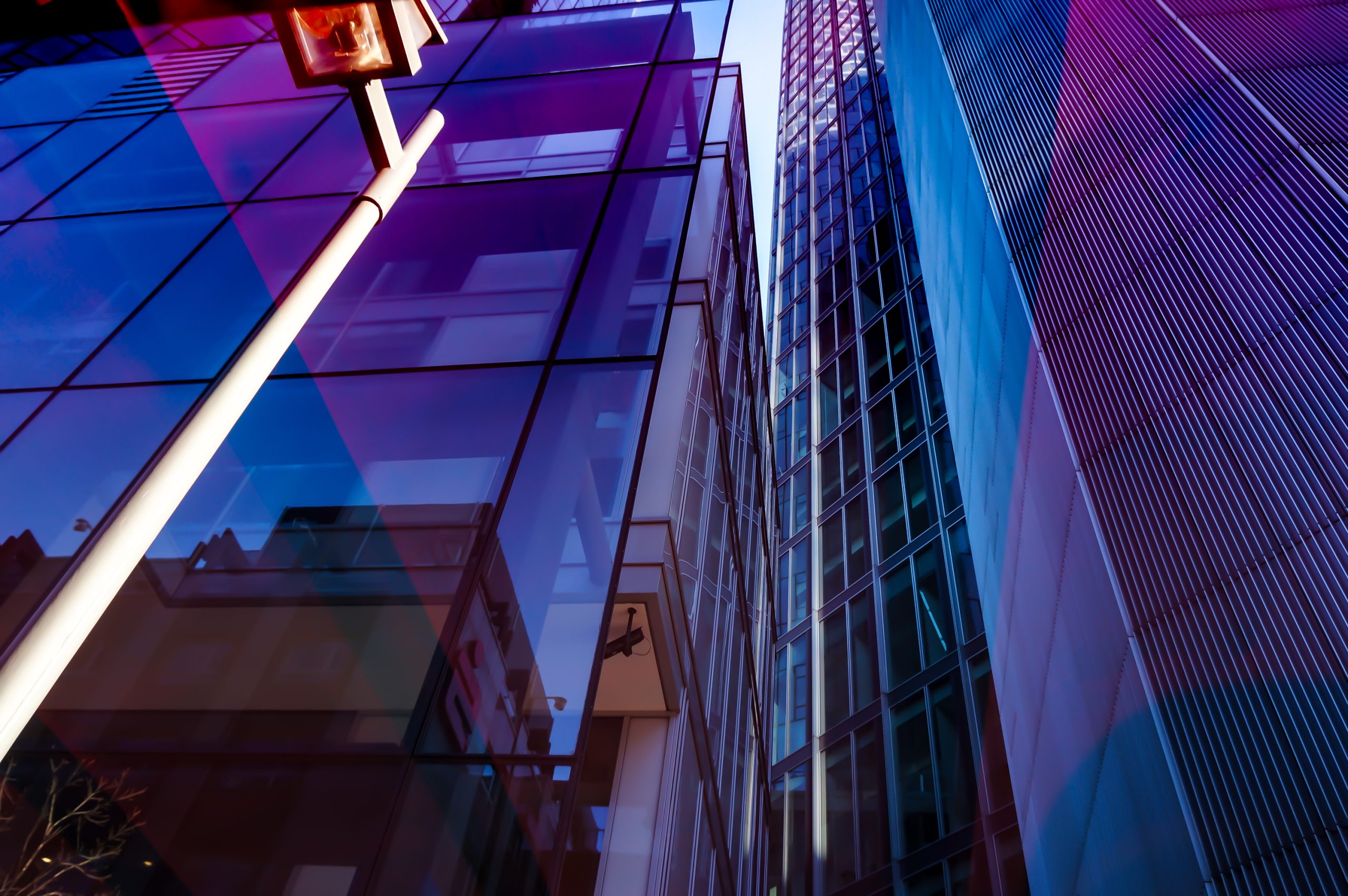 Modern glass office buildings with reflective blue and purple tones in London