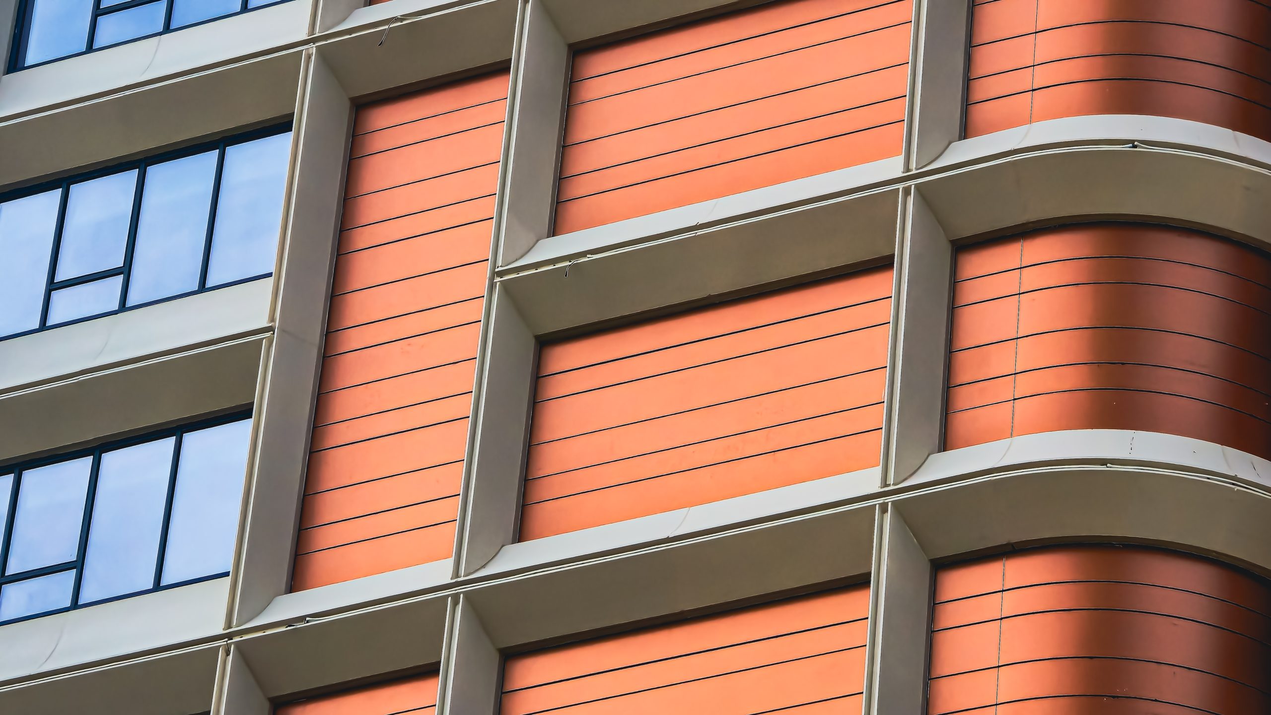Modern Architecture Facade with Orange Panels and Abstract Window Reflections