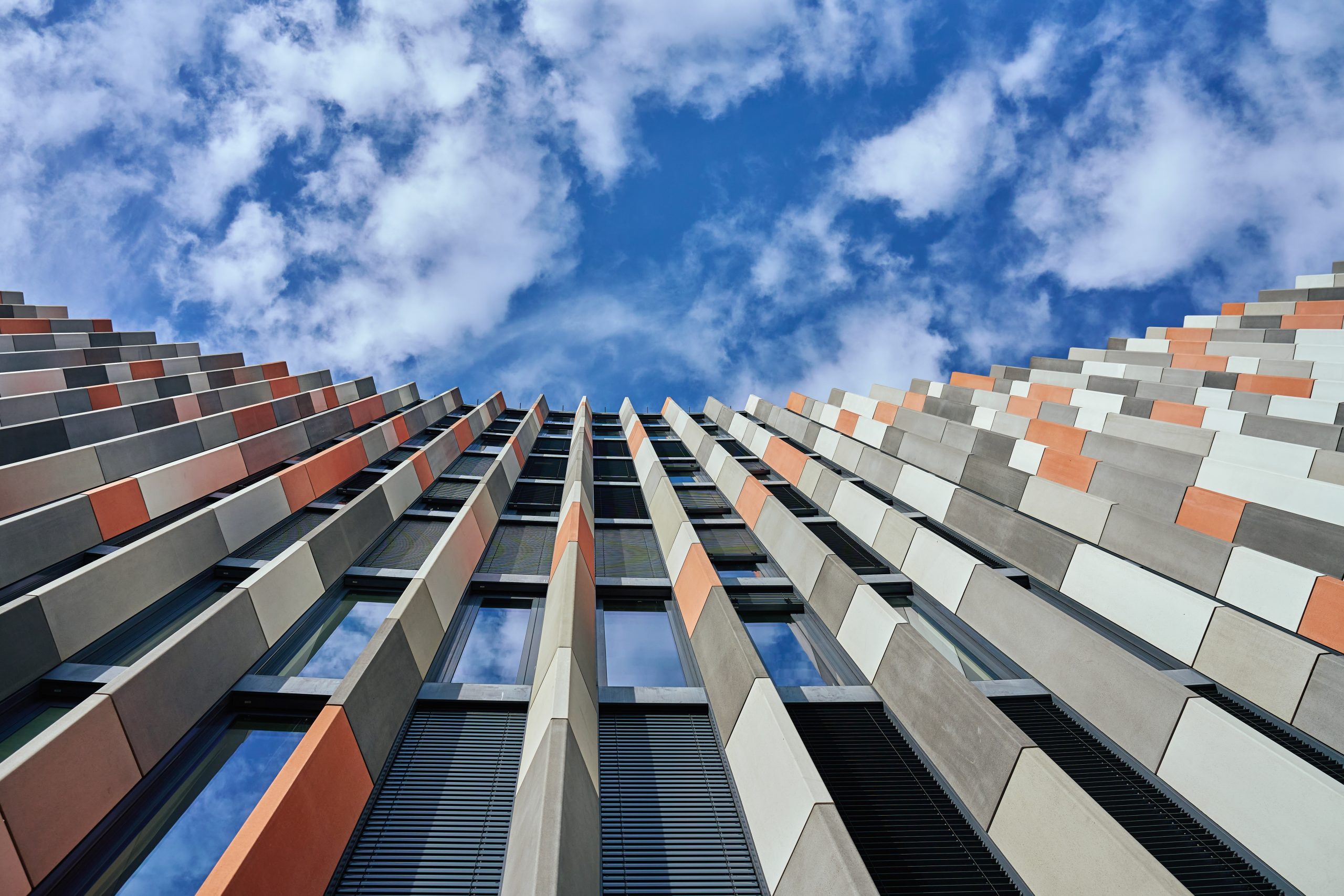 Modern UK office building viewed from below against a blue sky