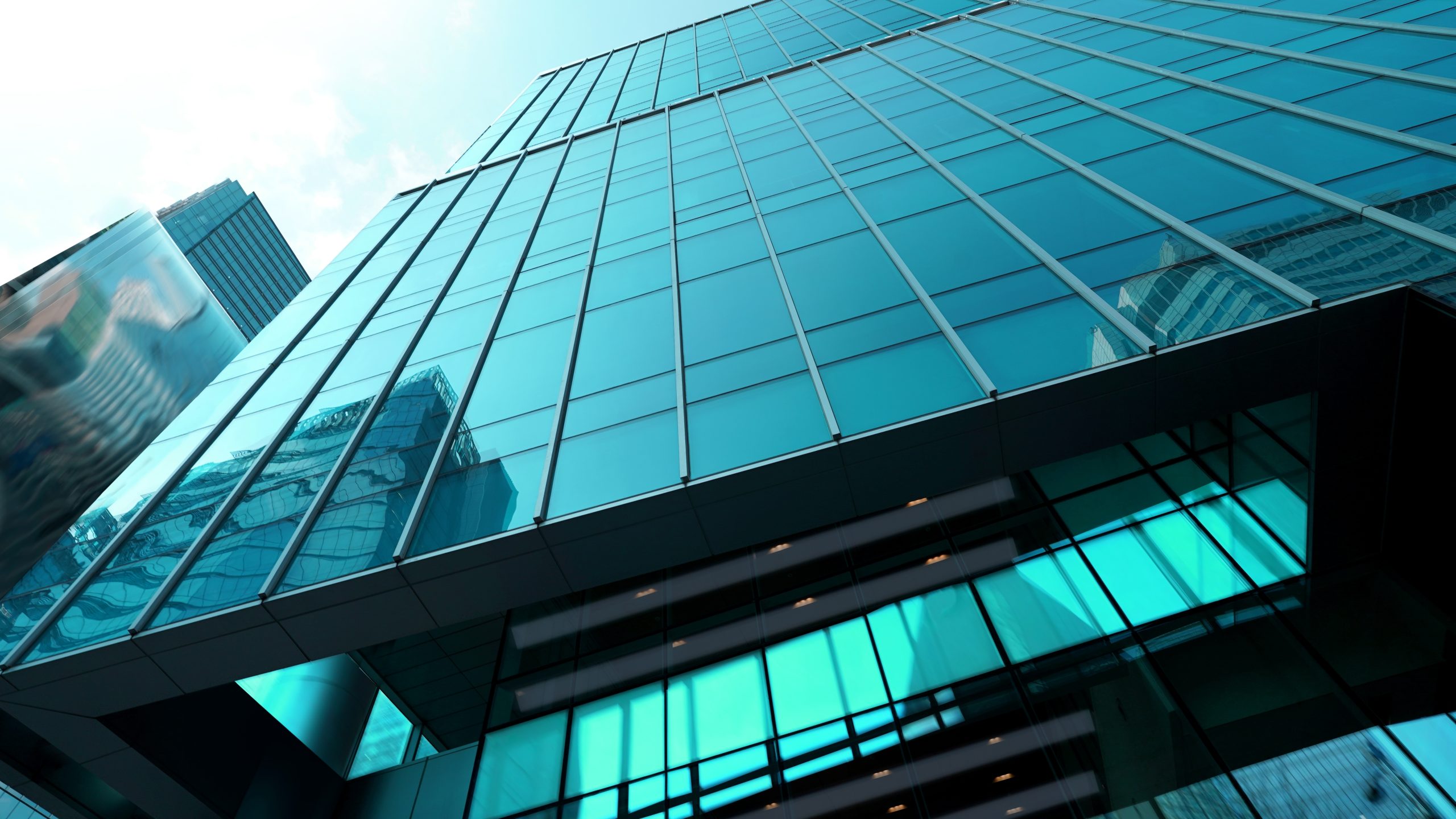 Modern financial services office building with blue glass facade reflecting city skyline, symbolising broking industry trends.