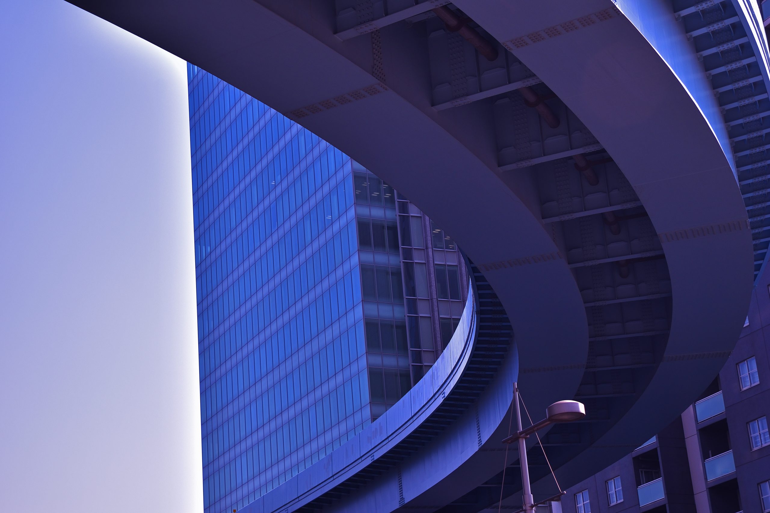 Modern city building with blue curved infrastructure representing financial and insurance market dynamics