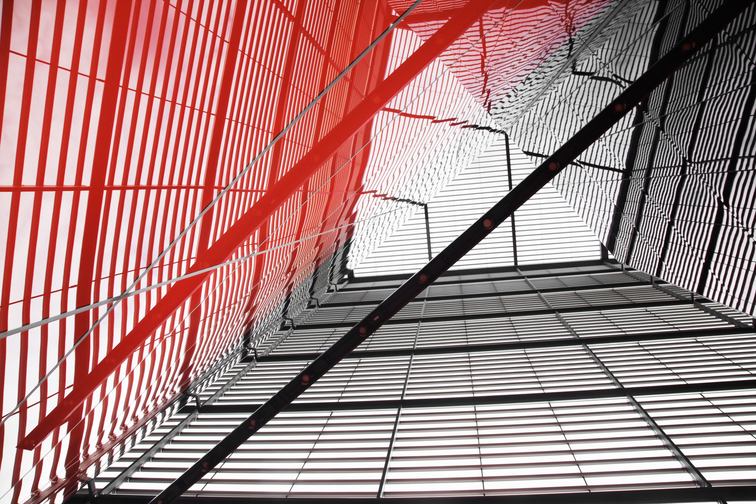 Modern architectural structure with red framework and geometric patterns, symbolising regulatory structure and compliance complexity