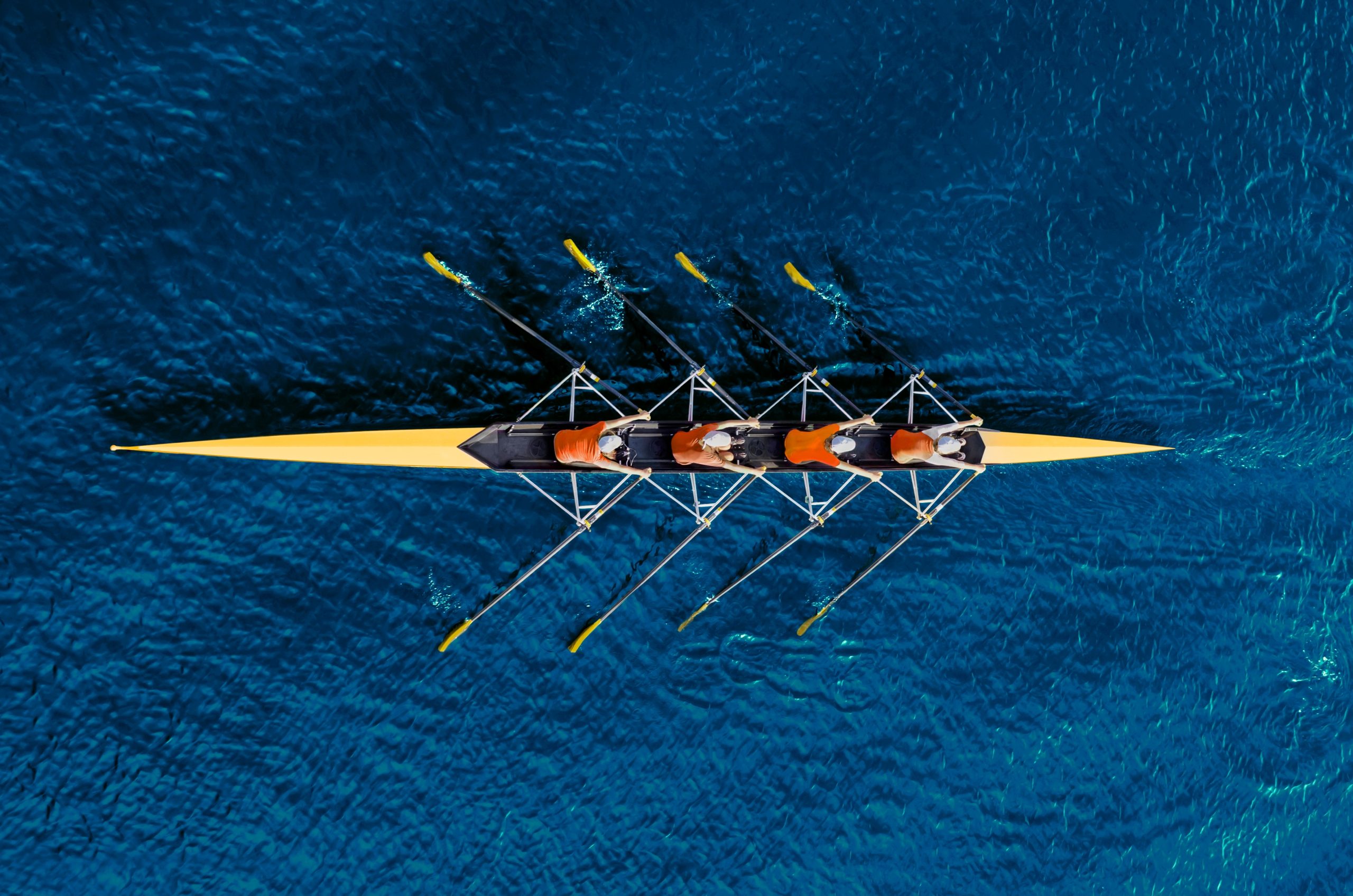 Rowing team racing on water representing international athletes and UK tax on foreign performers