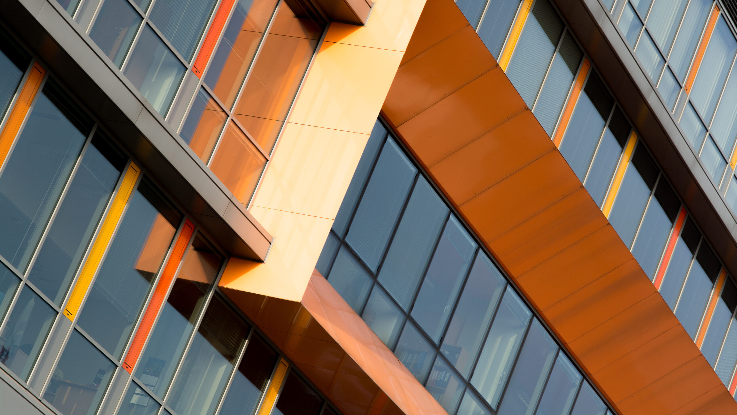 Modern office building exterior with glass windows and orange architectural panels