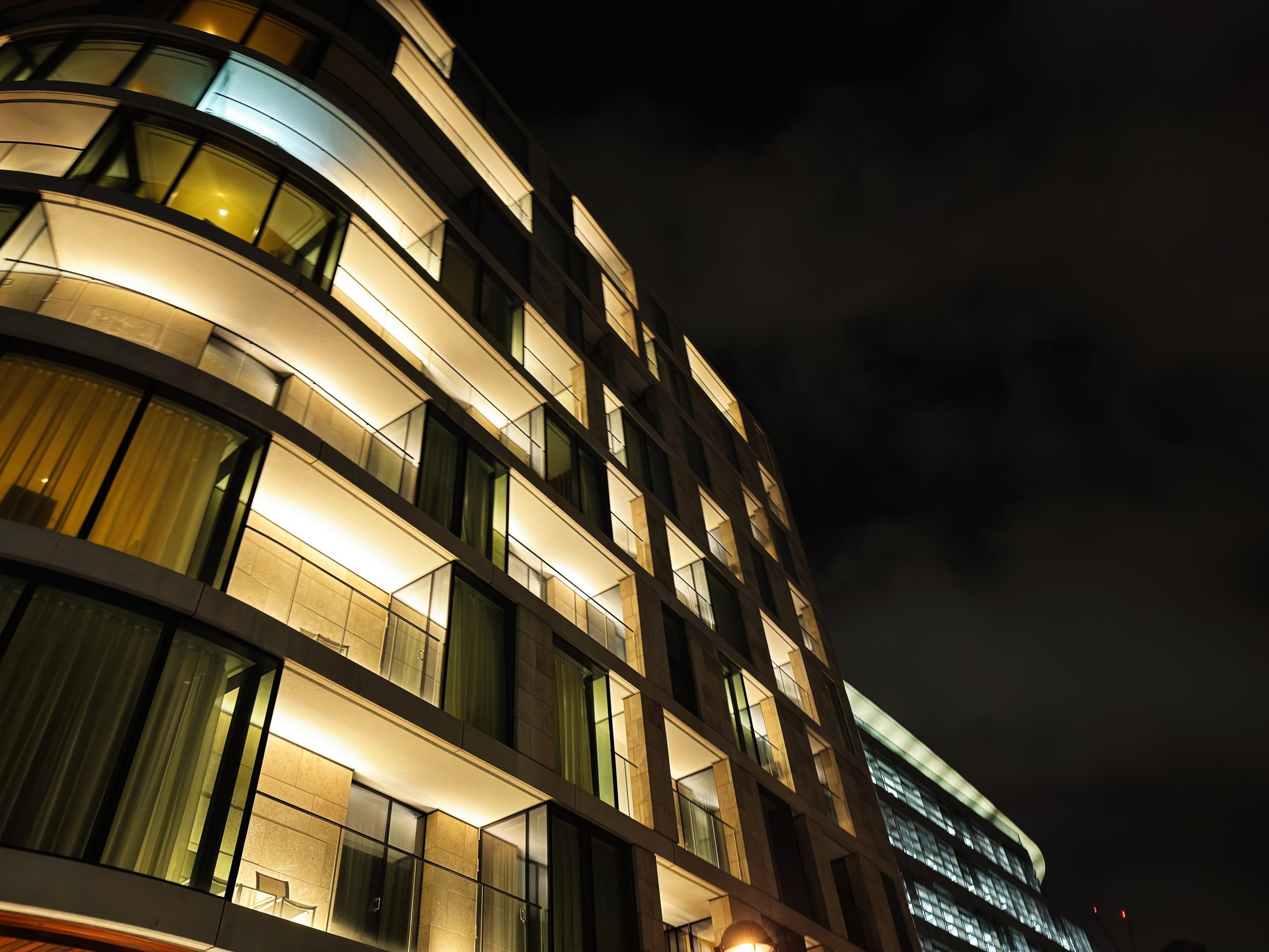 Modern hotel building illuminated at night, representing the UK hospitality sector.