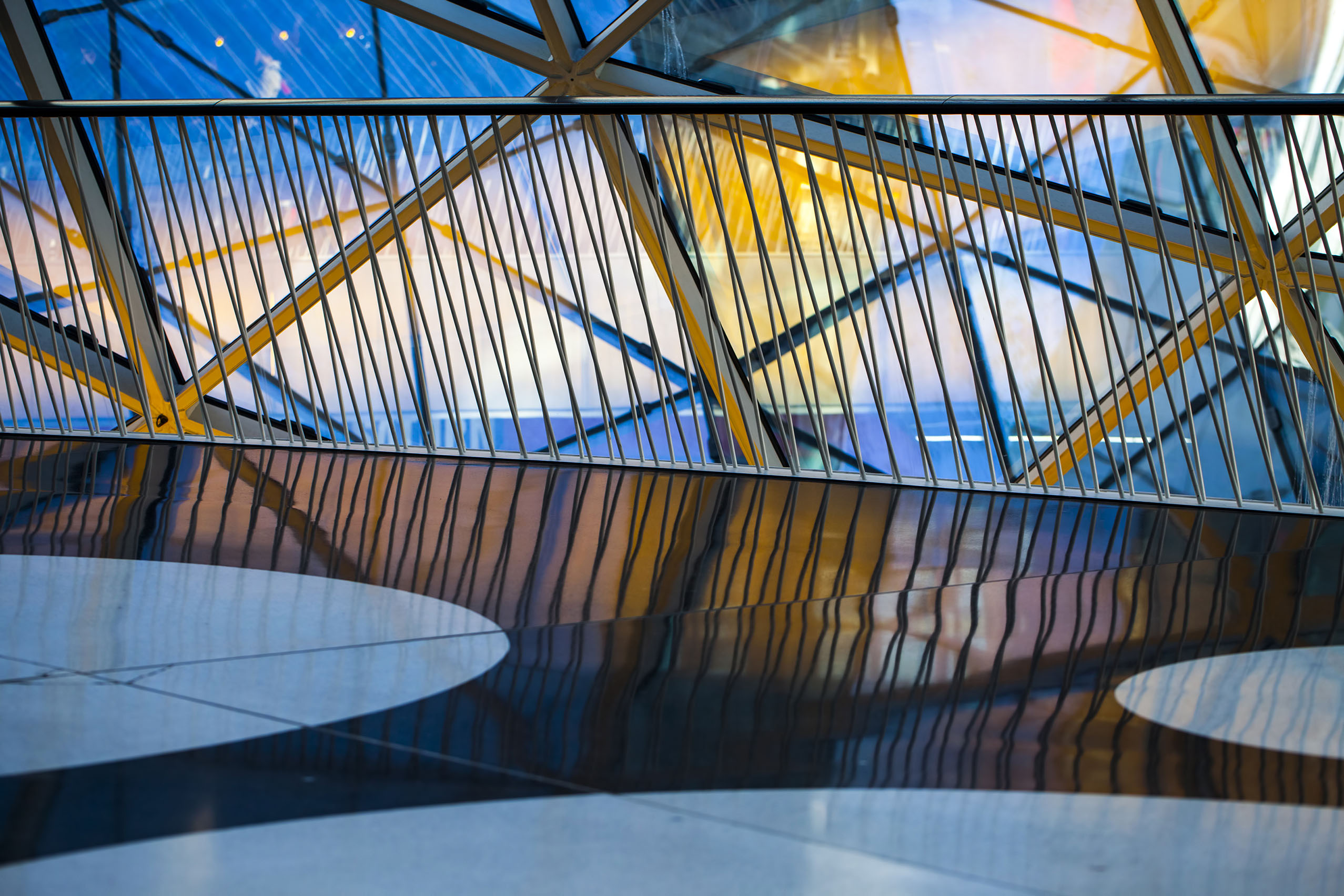 Modern architectural interior with glass panels, geometric lines and reflective surfaces