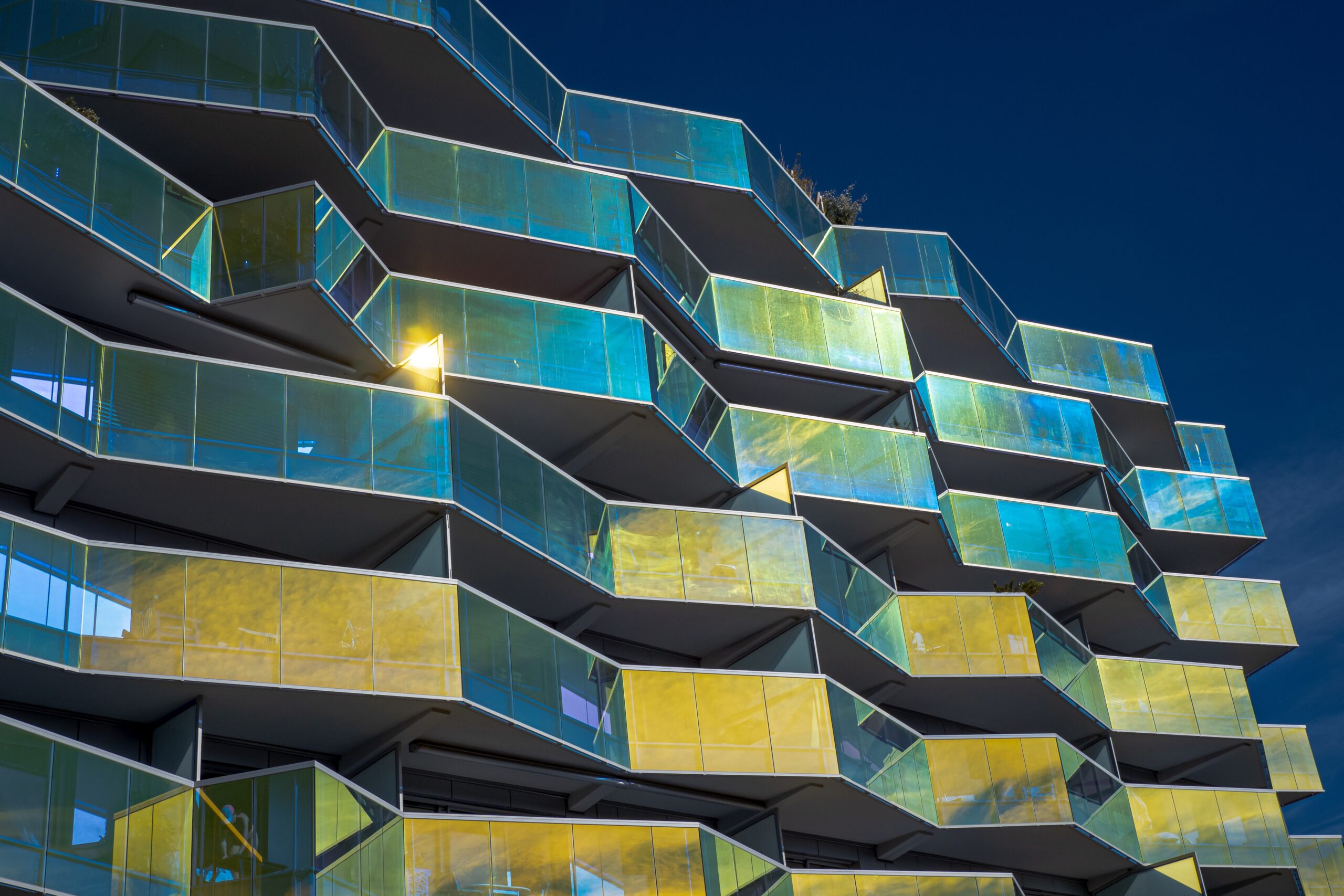 Modern building with geometric glass balconies reflecting light