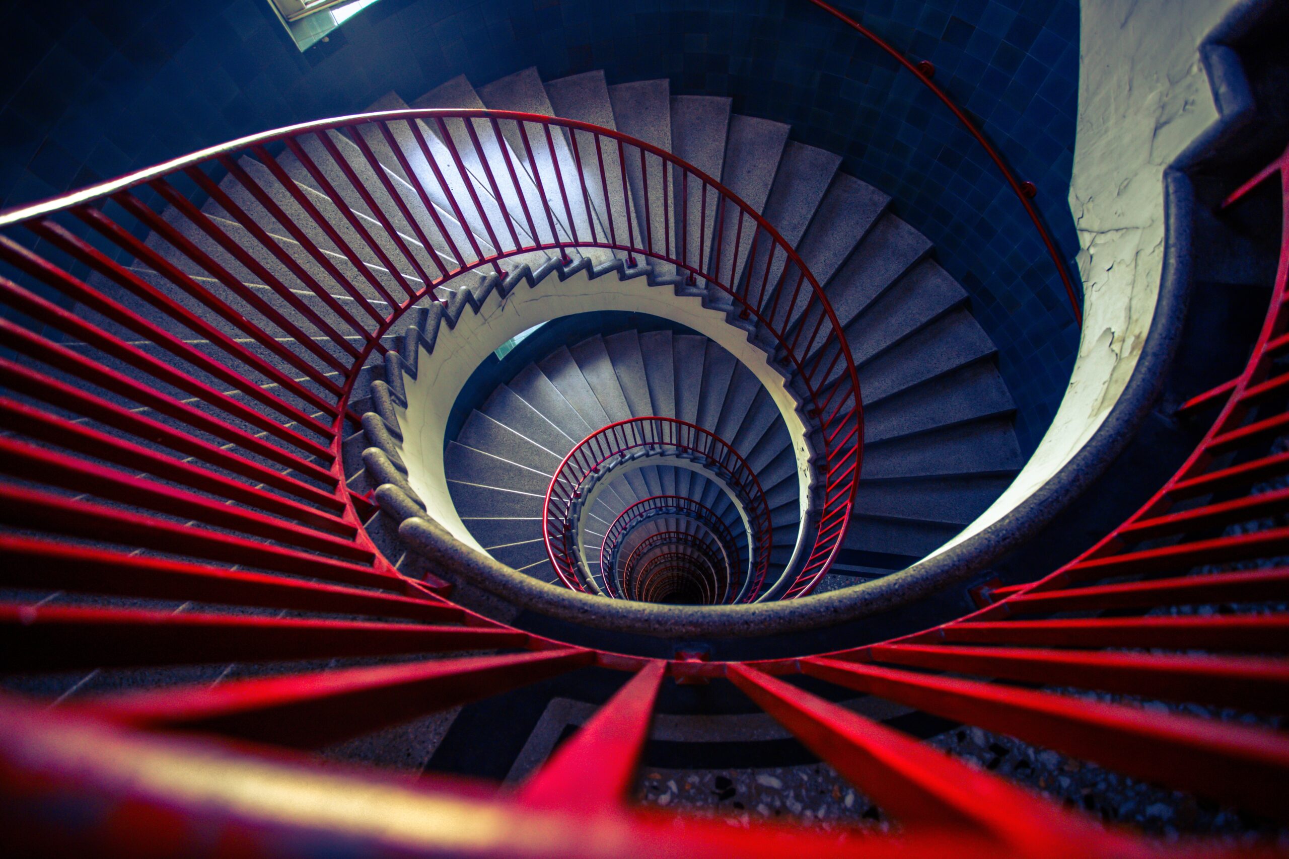 Spiral staircase with red railings viewed from above